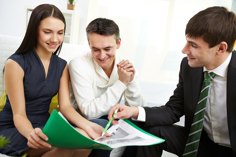 Portrait of modern couple listening to manager explanation of insurance.